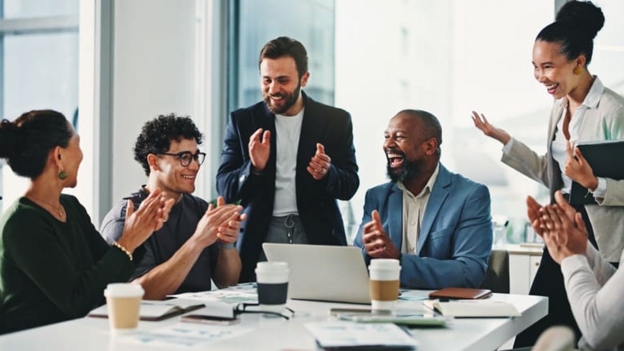 Business people, applause and celebration at office meeting, happy and achievement with revenue goals. Team, men and women with clapping, cheers and motivation with success at investment agency