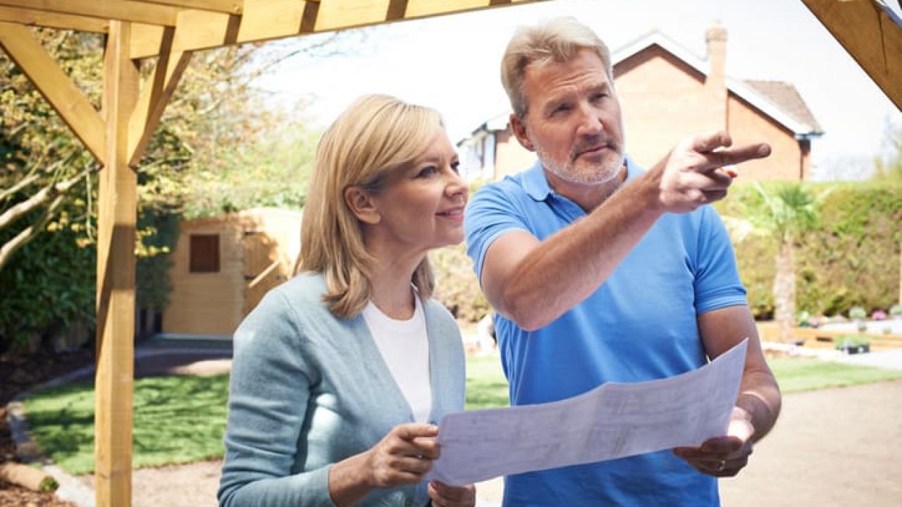 Mature Woman Discussing Plan With Landscape Gardener